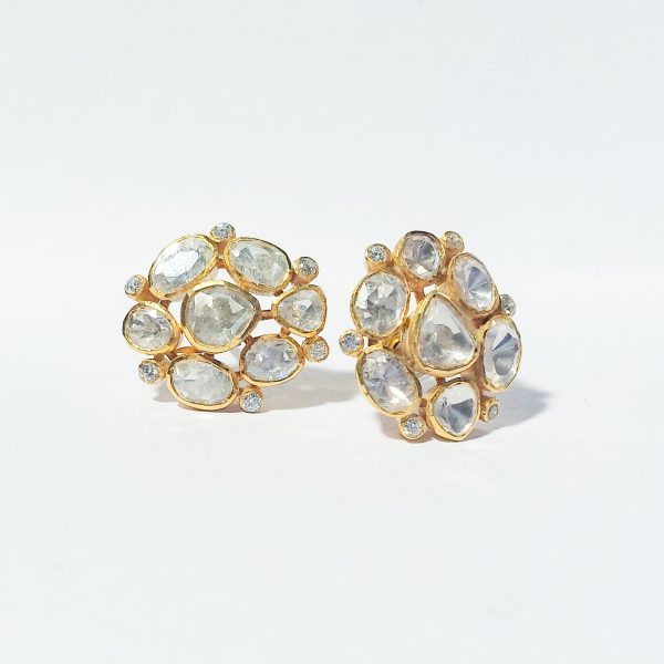A close-up image of elegant multi stone earrings with clear, polished stones set in gold-plated silver, arranged in a circular design. The intricate details highlight the sparkle of each stone against a white background.